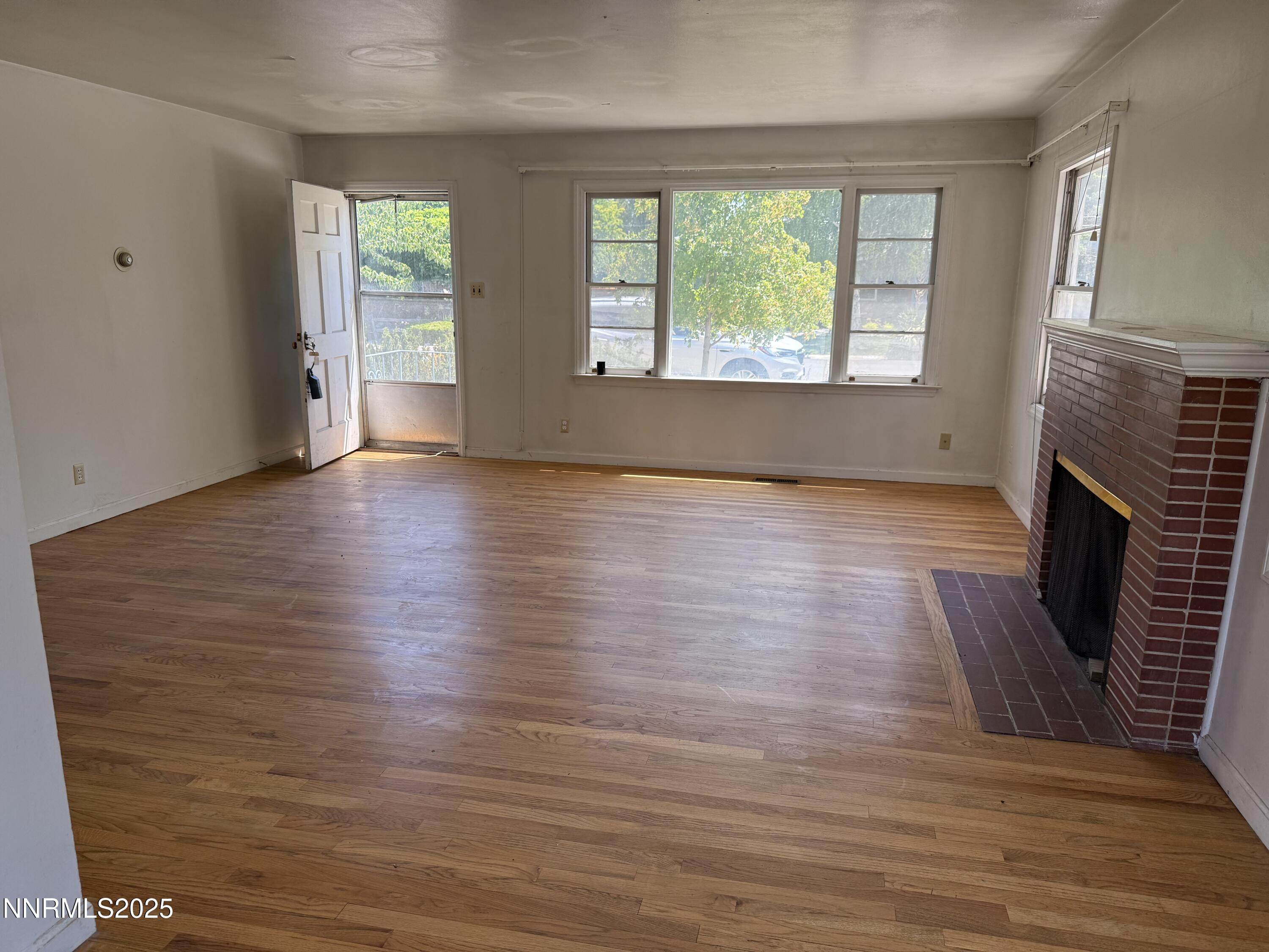 1075 Memory Lane Reno, NV 89509 - Photo 4 of 11 an empty room with wooden floor and windows