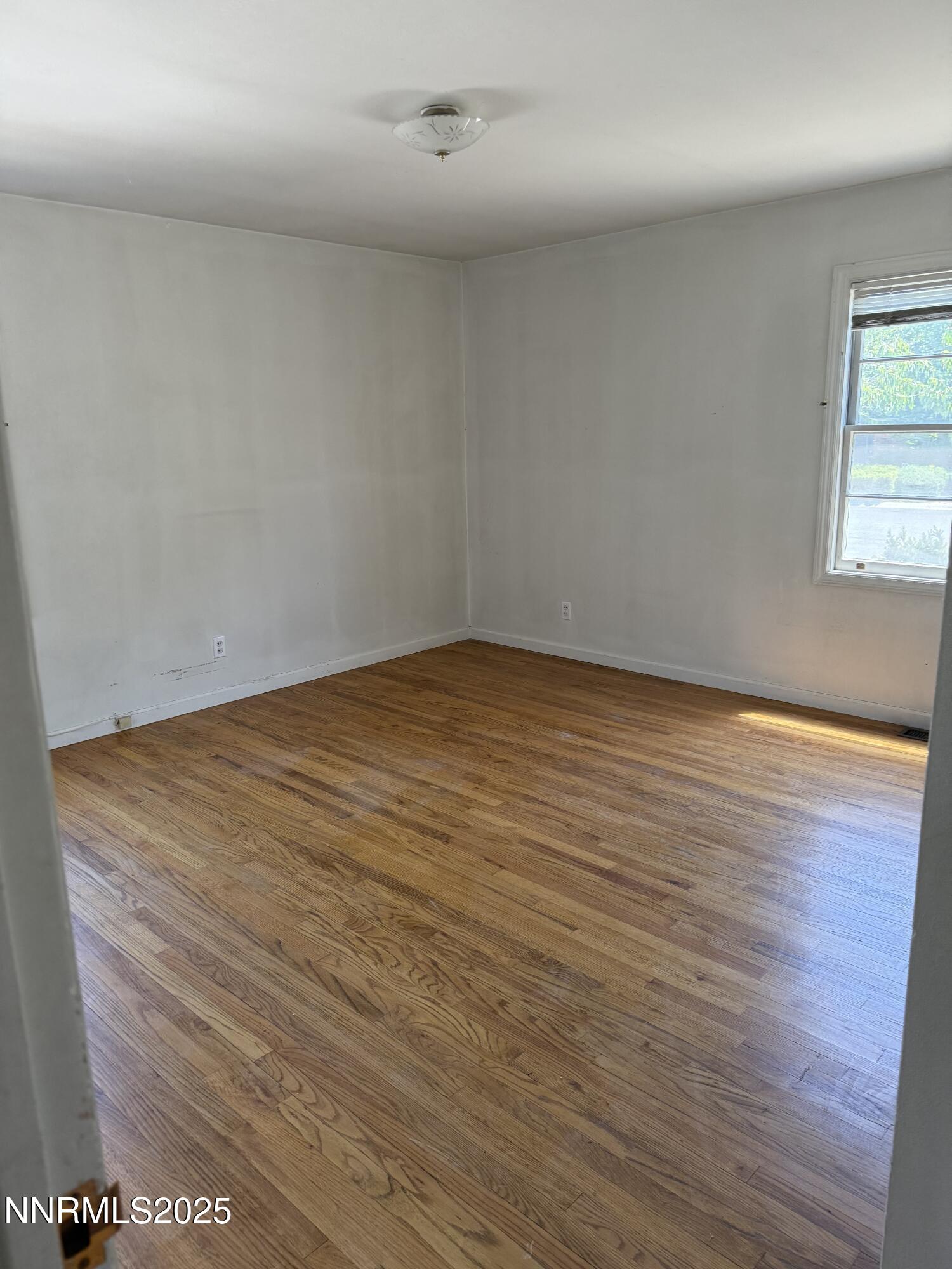 1075 Memory Lane Reno, NV 89509 - Photo 5 of 11 an empty room with wooden floor and windows