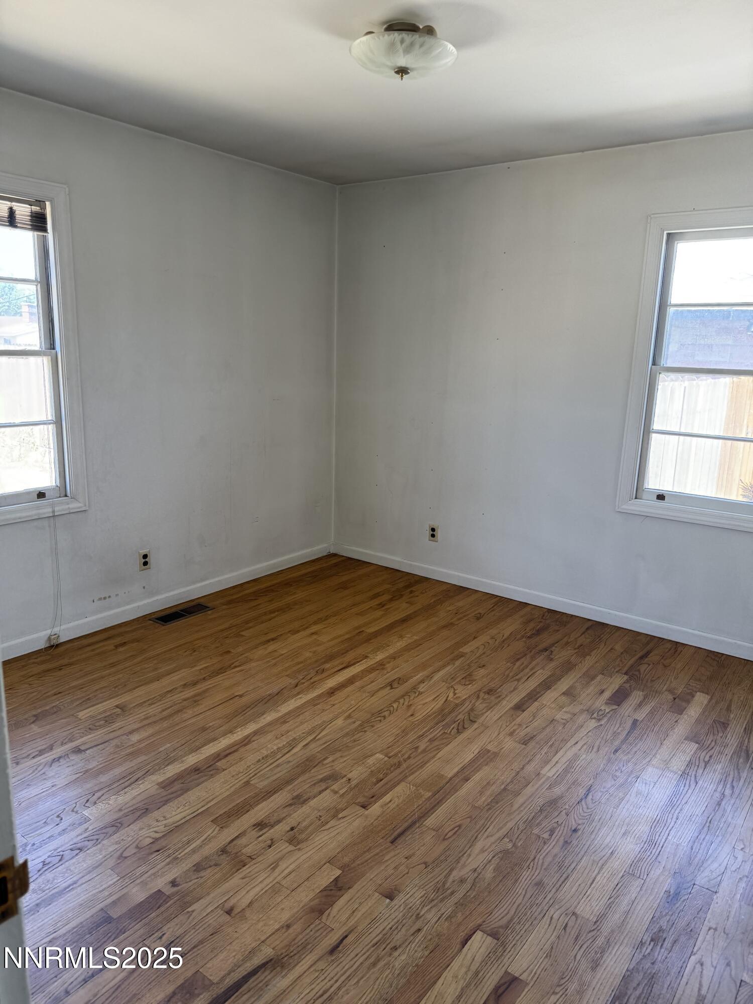 1075 Memory Lane Reno, NV 89509 - Photo 6 of 11 an empty room with wooden floor and windows