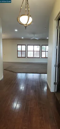 a view of empty room with wooden floor and window