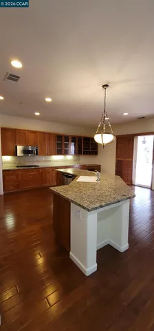 a large kitchen with stainless steel appliances a large counter top