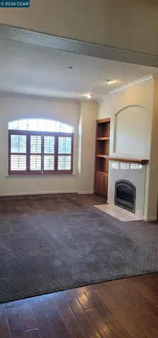 a view of empty room with a fireplace and wooden floor