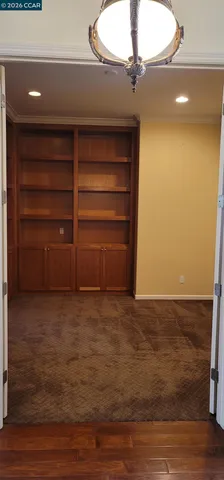 a view of an empty room with a fireplace and wooden floor