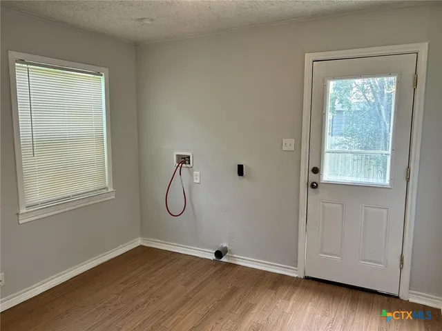 a view of a room with wooden floor and windows
