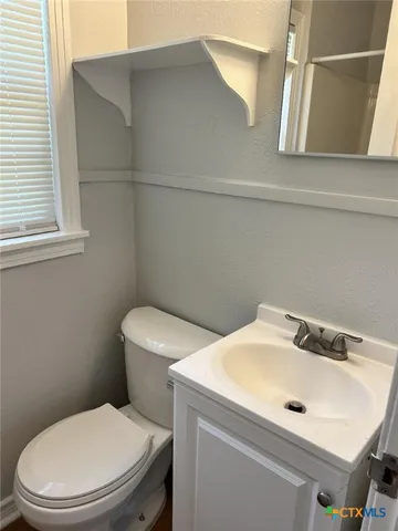 a bathroom with a sink a toilet and mirror