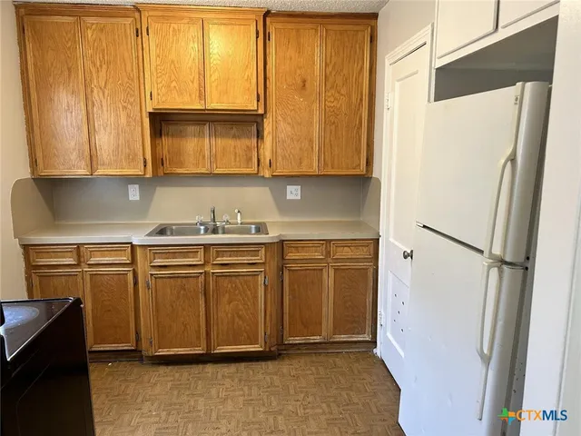 a kitchen with stainless steel appliances granite countertop a refrigerator sink and cabinets
