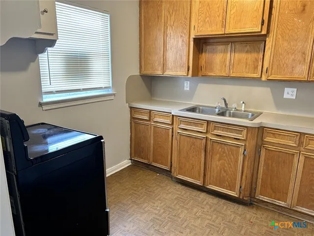 a kitchen with cabinets appliances and a window