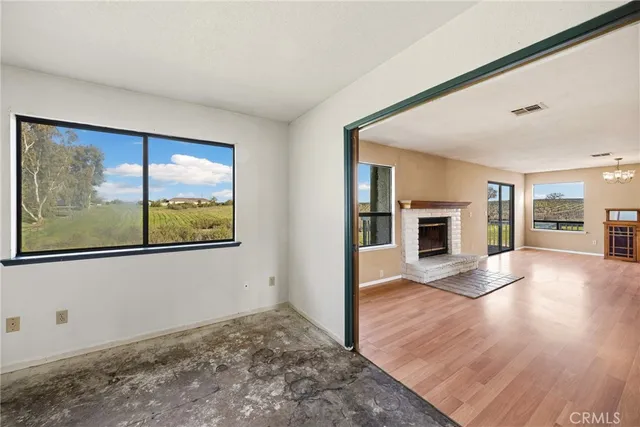 a view of empty room with wooden floor and fireplace