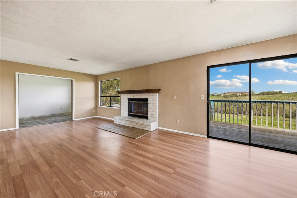 6980 Cabernet Place Paso Robles, CA 93446 - Photo 7 of 30 wooden floor fireplace and windows in an empty room