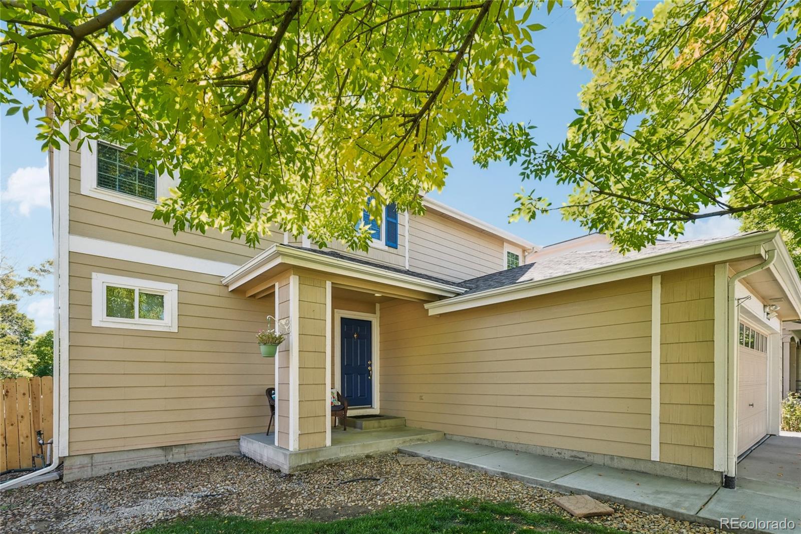 9230 Cook Street Thornton, CO 80229 - Photo 2 of 34 a view of a white house next to a yard with large tree