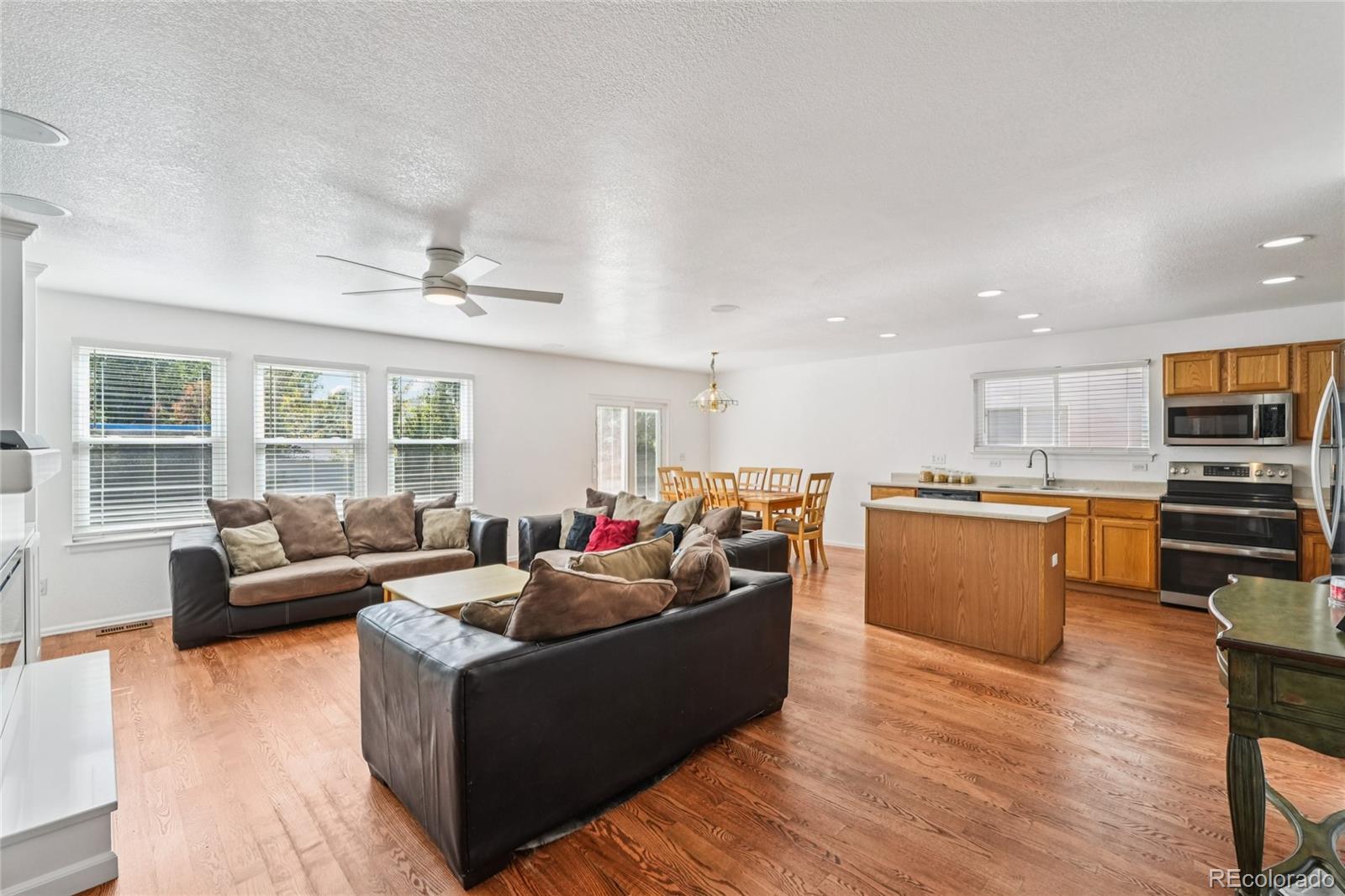 9230 Cook Street Thornton, CO 80229 - Photo 4 of 34 a living room with couches and kitchen view with wooden floor