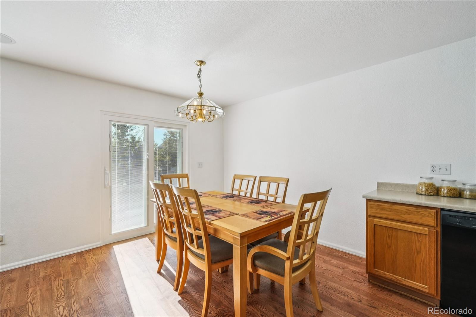 9230 Cook Street Thornton, CO 80229 - Photo 9 of 34 a view of a dining room with furniture wooden floor and chandelier