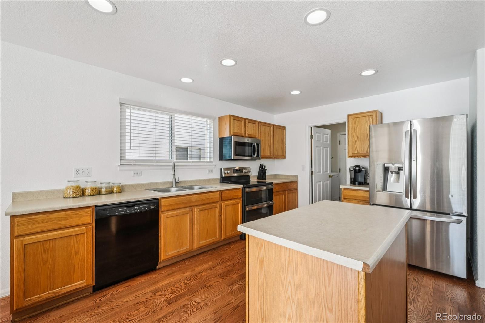 9230 Cook Street Thornton, CO 80229 - Photo 10 of 34 a kitchen with stainless steel appliances granite countertop a sink stove refrigerator and cabinets