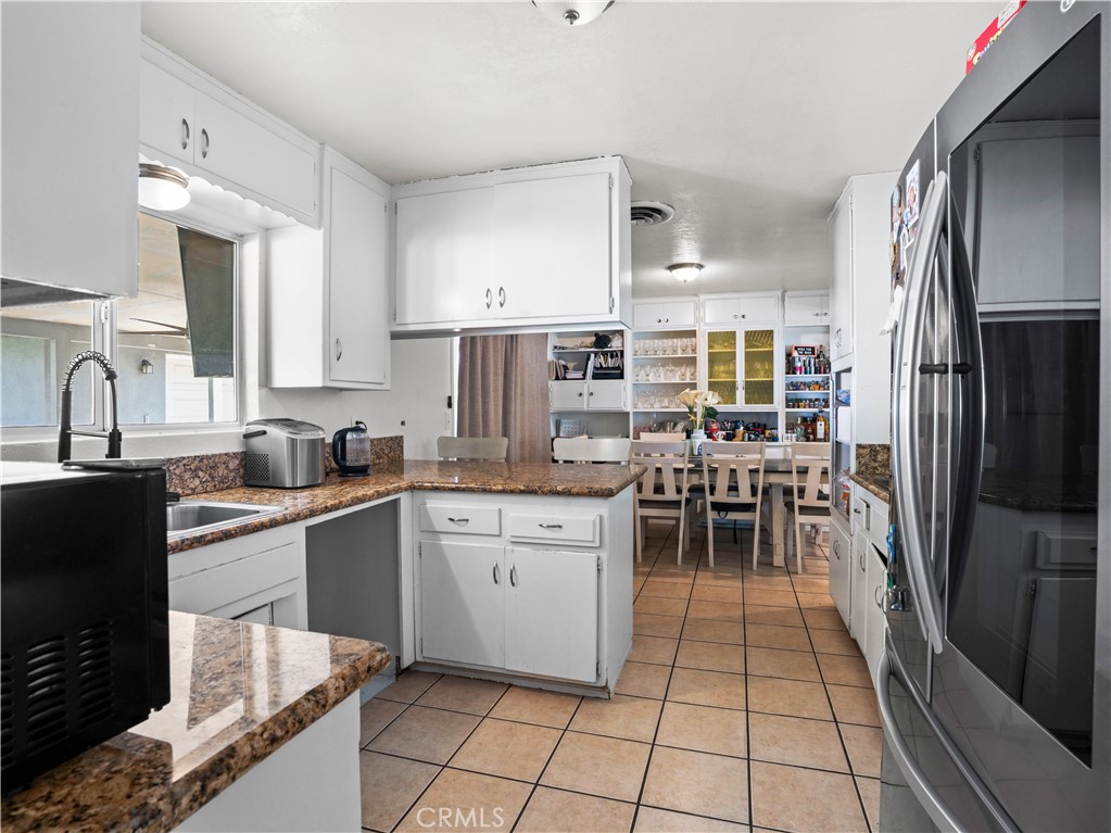 1455 North Alice Avenue Rialto, CA 92376 - Photo 11 of 23 a kitchen with stainless steel appliances granite countertop a refrigerator and a stove top oven