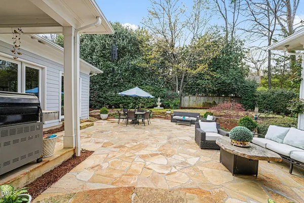 a view of a patio with dining table and chairs under an umbrella