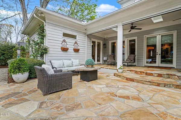 a view of a patio with couches table and chairs and potted plants