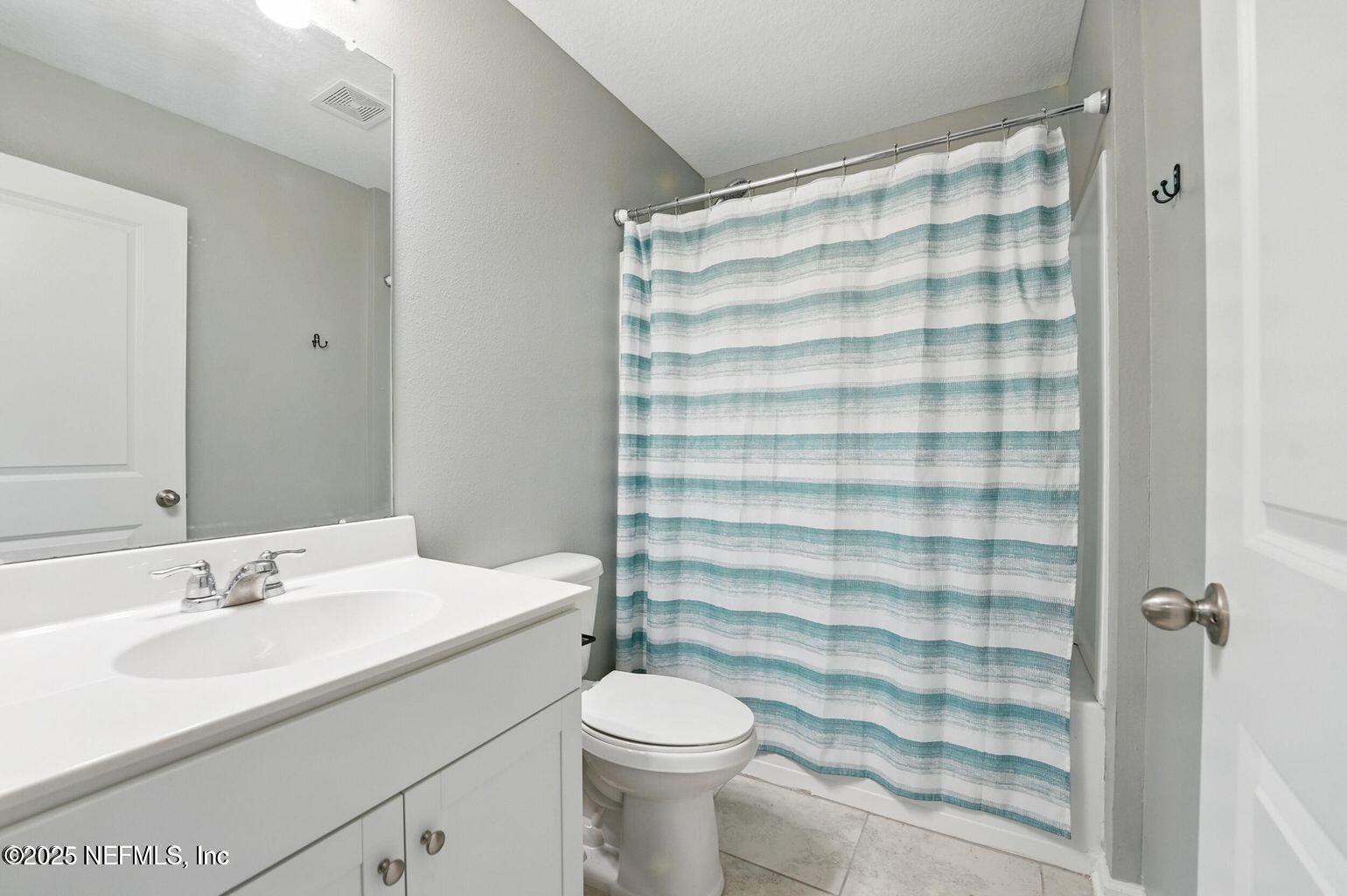 11624 Palladio Way Jacksonville, FL 32218 - Photo 12 of 15 a bathroom with a sink a toilet a shower curtain and a large mirror