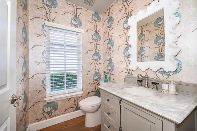 a bathroom with a granite countertop sink mirror vanity and toilet