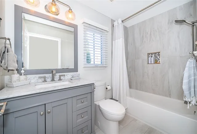 a bathroom with a double vanity sink toilet and shower