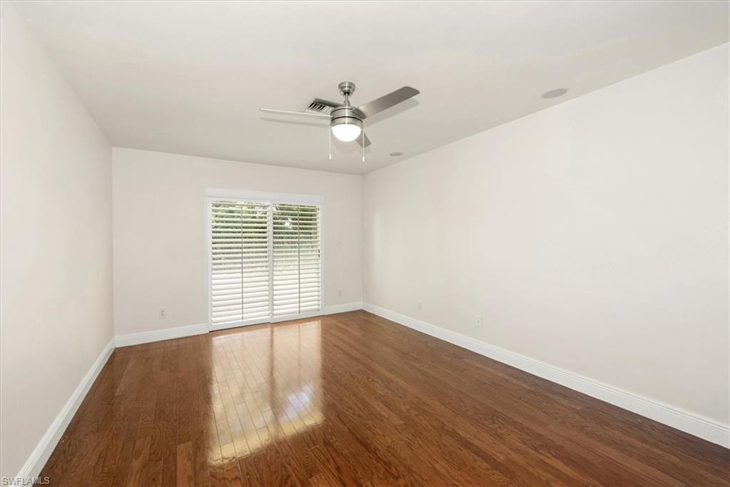 2252 Royal Lane Naples, FL 34112 - Photo 15 of 42 Second Bedroom with natural wood flooring and a ceiling fan, plantation shutters on slider