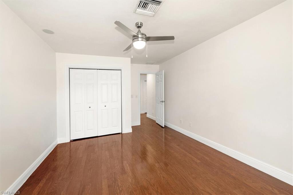 2252 Royal Lane Naples, FL 34112 - Photo 16 of 42 Unfurnished Second bedroom with dark wood floors, facing spacious closet, and ceiling fan