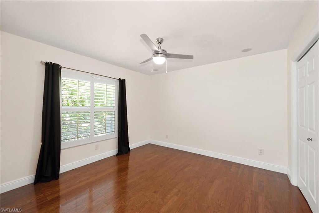 2252 Royal Lane Naples, FL 34112 - Photo 17 of 42 Third Bedroom with wood finished floors, plantation shutters and stylish ceiling fan