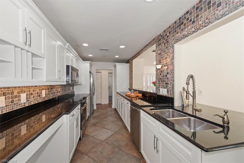 2252 Royal Lane Naples, FL 34112 - Photo 20 of 42 Kitchen with open shelves, white cabinets, recessed lighting, granite counters, and stainless steel appliances