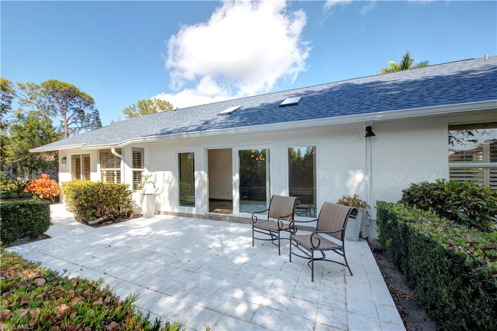 2252 Royal Lane Naples, FL 34112 - Photo 40 of 42 Rear view of property featuring stucco siding, a NEW shingled roof, and NEW gutters and a patio