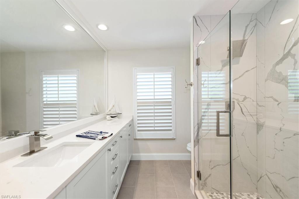 2252 Royal Lane Naples, FL 34112 - Photo 5 of 42 Guest Bathroom with new quartz vanity sink and faucets. New quartz shower, light tile patterned floors, recessed lighting, and plenty of natural light