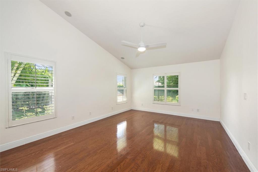 2252 Royal Lane Naples, FL 34112 - Photo 9 of 42 Master Bedroom with wood flooring, high vaulted ceiling, stylish ceiling fan, plantation shutters