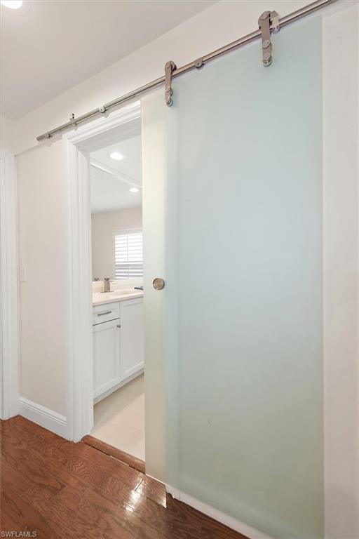 2252 Royal Lane Naples, FL 34112 - Photo 10 of 42 Guest Bath entry featuring a barn door, light wood floors, and recessed lighting