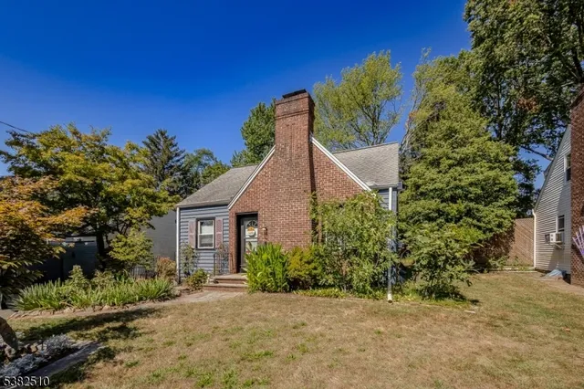a view of a house with a small yard and potted plants