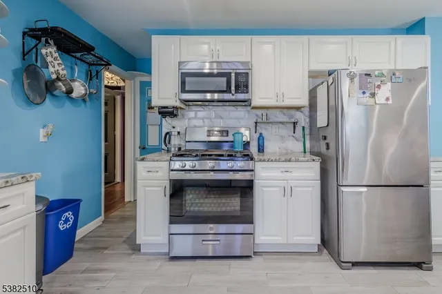 a kitchen with stainless steel appliances a stove a refrigerator and a microwave
