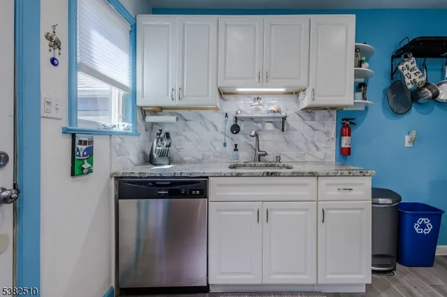 a kitchen with stainless steel appliances granite countertop a stove and a white cabinets