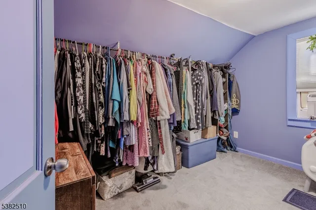 a view of walk in closet with clothes