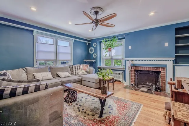 a living room with furniture a fireplace and a large window