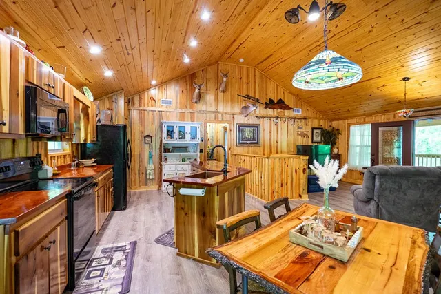 a living room with furniture a refrigerator and a flat screen tv