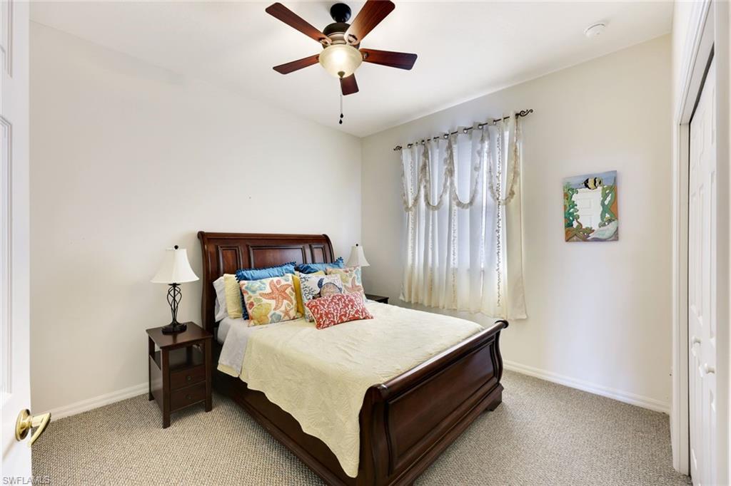 3530 Lansing Loop, Unit 202 Estero, FL 33928 - Photo 9 of 35 a bedroom with a bed and a chandelier