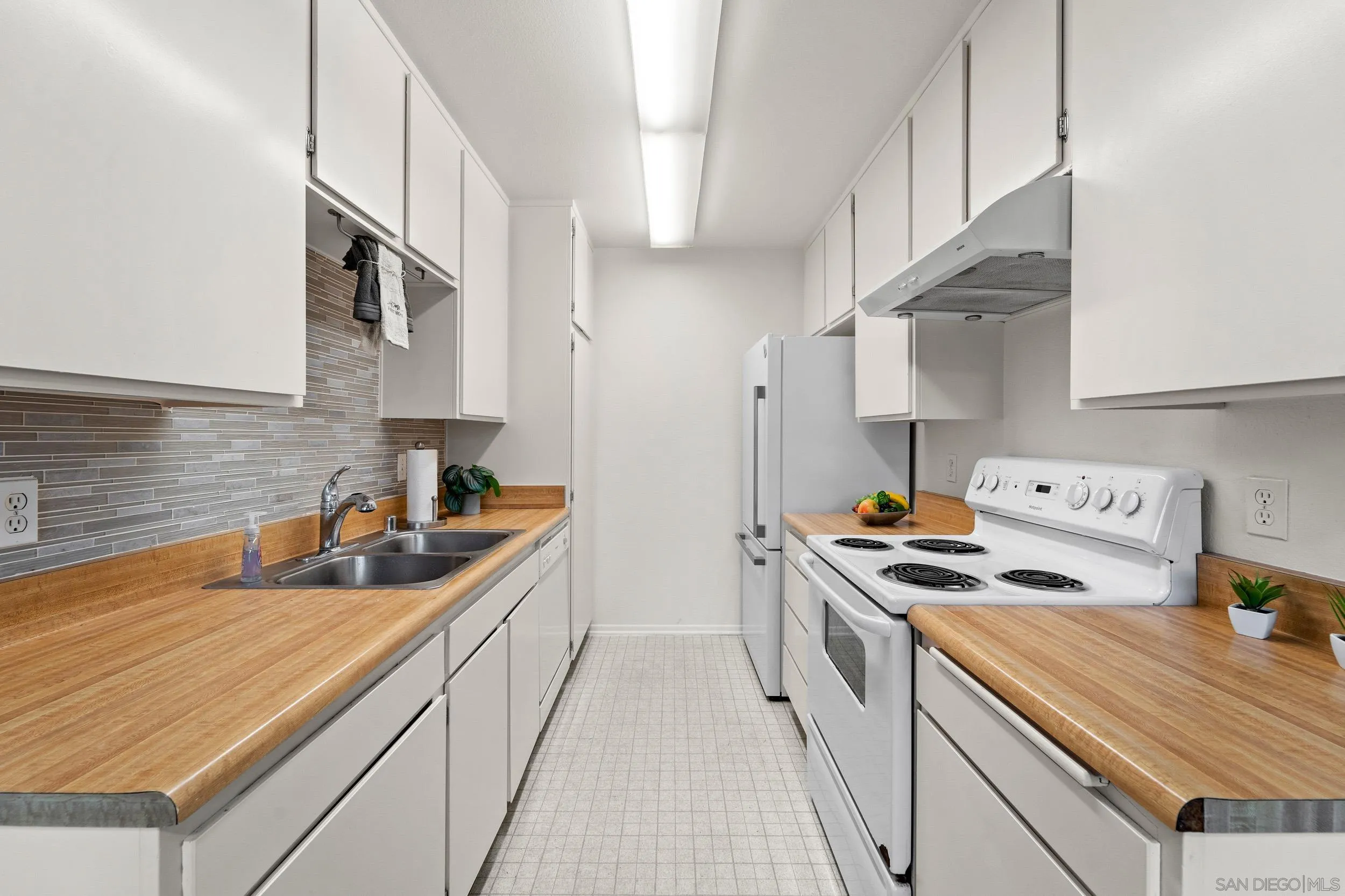 8640 Via Mallorca, Unit A La Jolla, CA 92037 - Photo 16 of 24 a kitchen with stainless steel appliances a sink a stove and a refrigerator