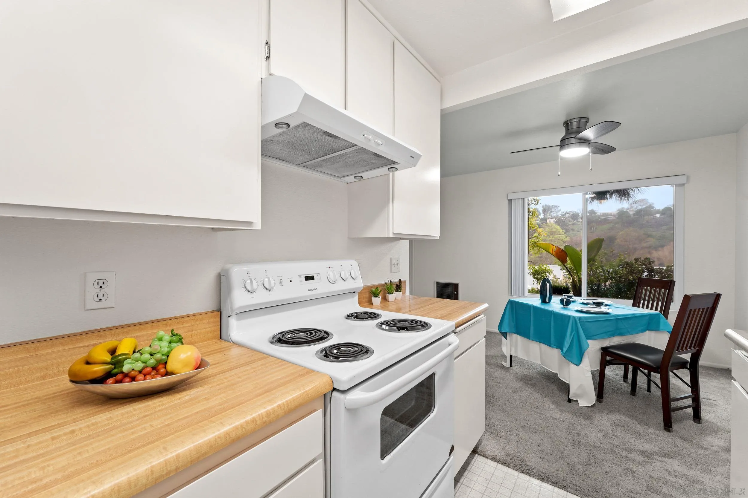 8640 Via Mallorca, Unit A La Jolla, CA 92037 - Photo 19 of 24 a kitchen with a stove a table and chairs