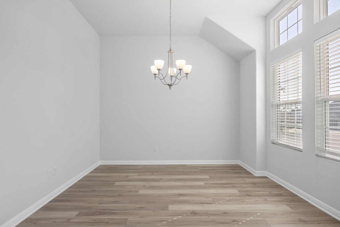 120 Northview Lane Georgetown, TX 78628 - Photo 5 of 33 Unfurnished room featuring light wood-style floors, a chandelier, and vaulted ceiling