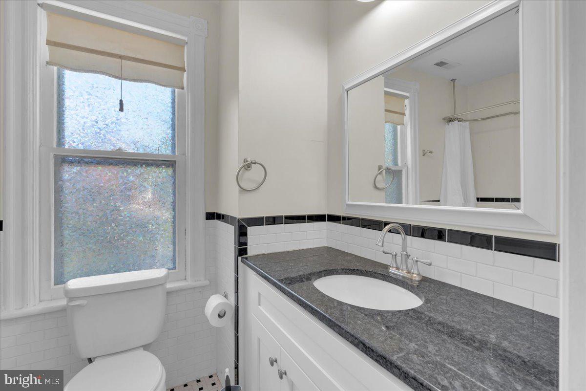 45 Broad Street Mount Holly, NJ 08060 - Photo 37 of 58 a bathroom with a granite countertop toilet sink and mirror