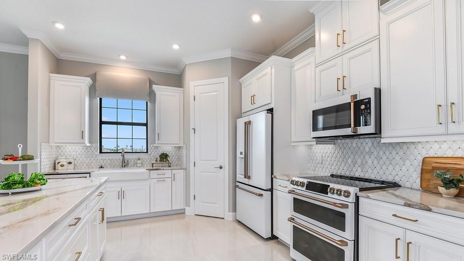 15335 Lucerna Street, Unit 201 Naples, FL 34114 - Photo 2 of 11 a kitchen with white cabinets and stainless steel appliances
