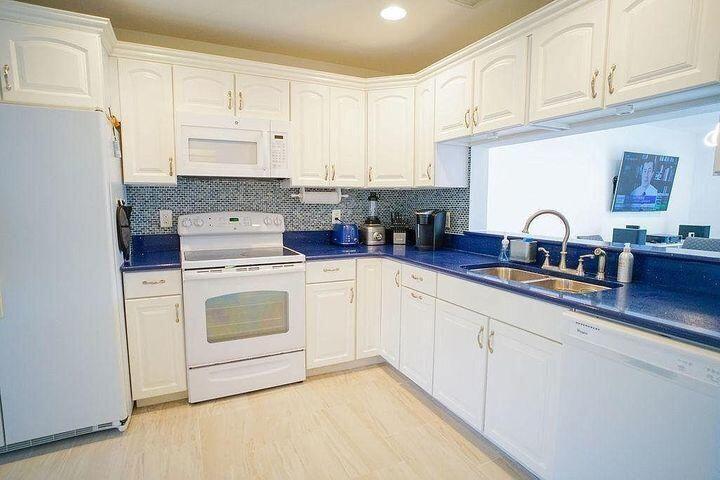 1511 Ocean Dunes Circle, Unit 1511 Jupiter, FL 33477 - Photo 12 of 27 a kitchen with white cabinets sink and white appliances