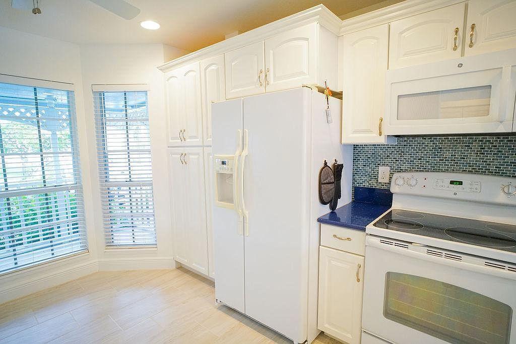 1511 Ocean Dunes Circle, Unit 1511 Jupiter, FL 33477 - Photo 2 of 27 a kitchen with a refrigerator and white cabinets