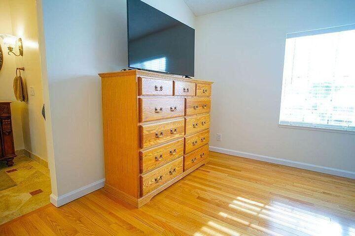 1511 Ocean Dunes Circle, Unit 1511 Jupiter, FL 33477 - Photo 22 of 27 a bedroom with a bed and a dresser