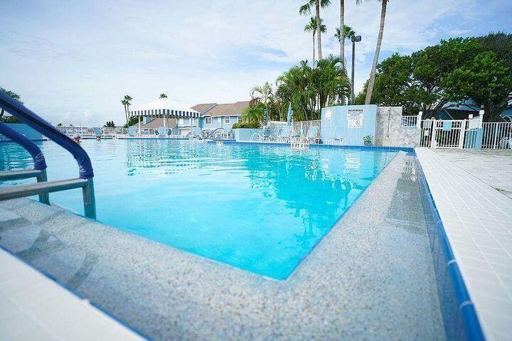 1511 Ocean Dunes Circle, Unit 1511 Jupiter, FL 33477 - Photo 24 of 27 a view of a swimming pool with a patio and a yard