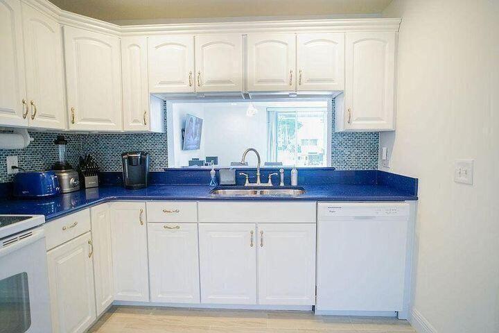 1511 Ocean Dunes Circle, Unit 1511 Jupiter, FL 33477 - Photo 10 of 27 a kitchen with granite countertop white cabinets and a sink