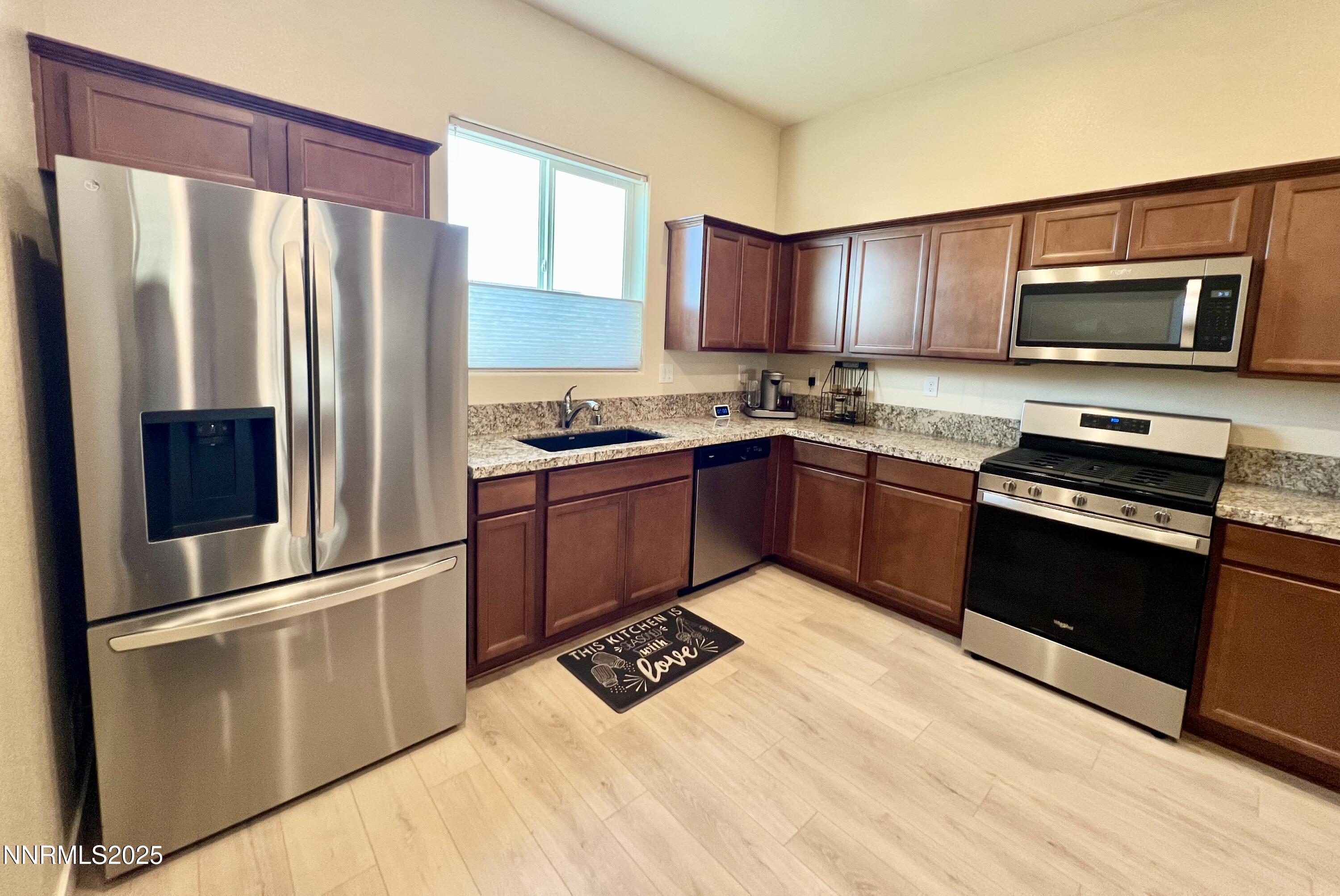 4969 Cavestone Road Sun Valley, NV 89433 - Photo 12 of 40 a kitchen with stainless steel appliances granite countertop a refrigerator stove top oven and sink
