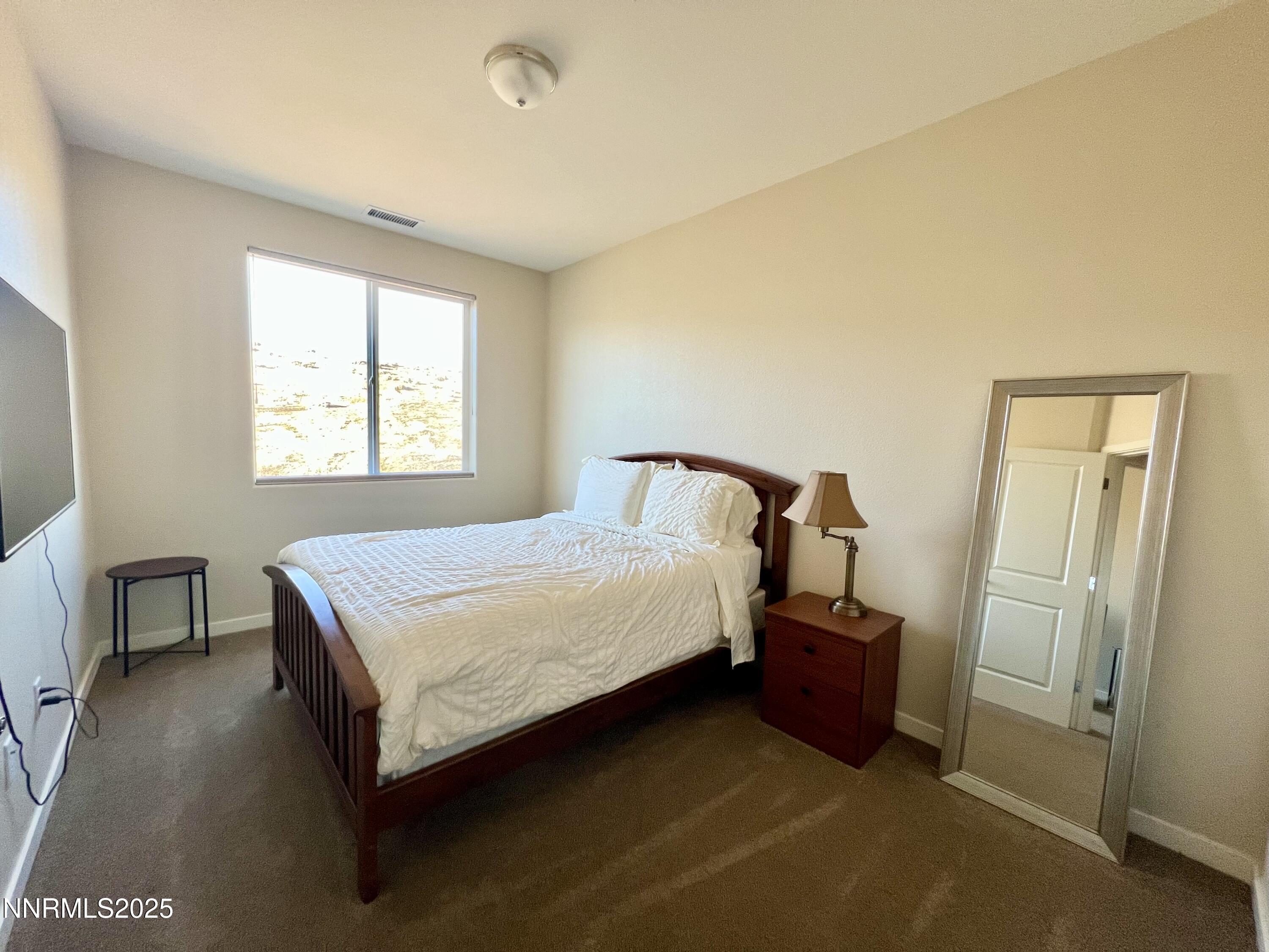 4969 Cavestone Road Sun Valley, NV 89433 - Photo 22 of 40 a bedroom with a bed and dresser